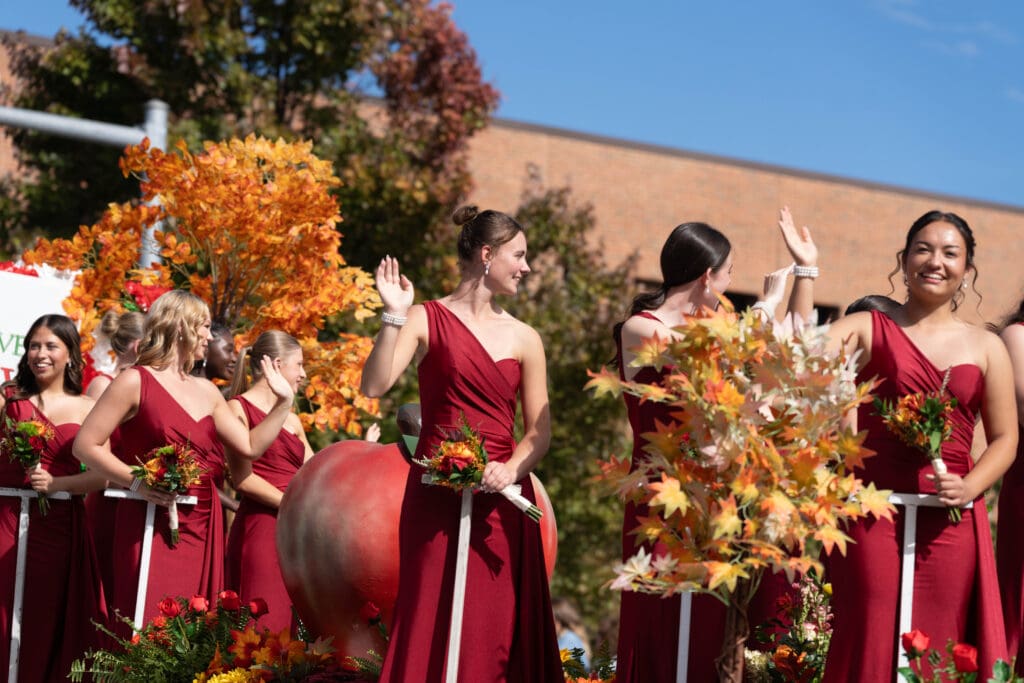 The Queen’s Court waves from the parade float