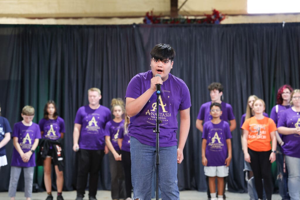 A young performer sings with the Apollo Civic Youth Theatre Company on the Indoor Arena stage